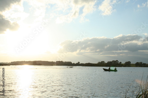 family in the boat during sunset © Vita Vanaga