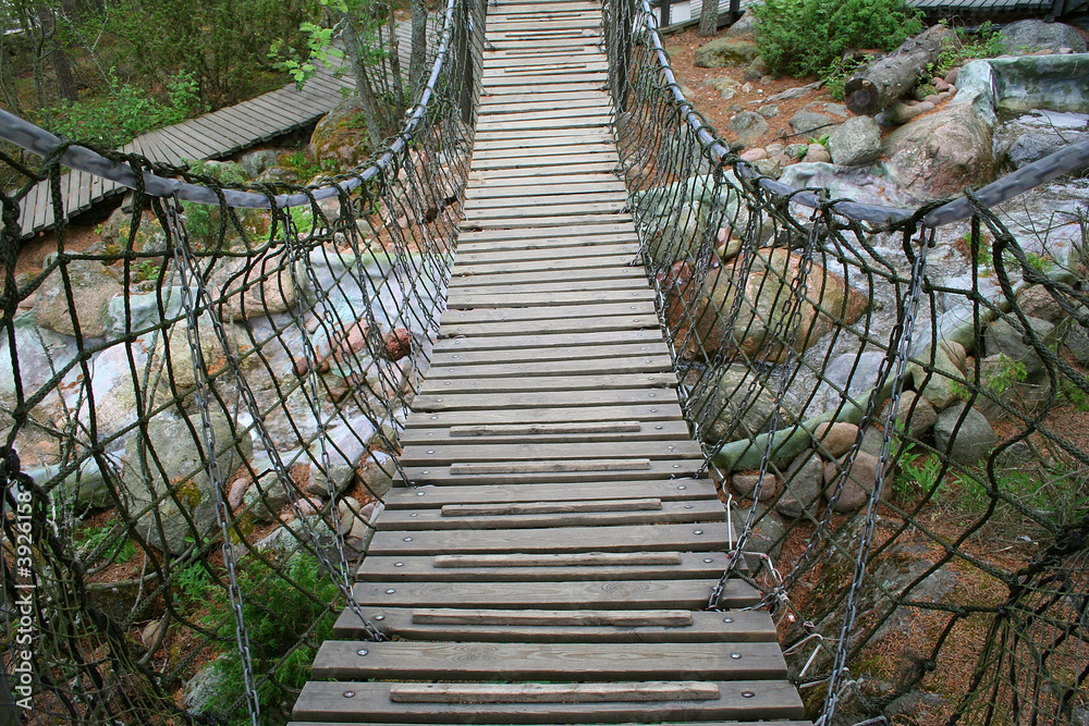 Fototapeta premium Suspension bridge over small river