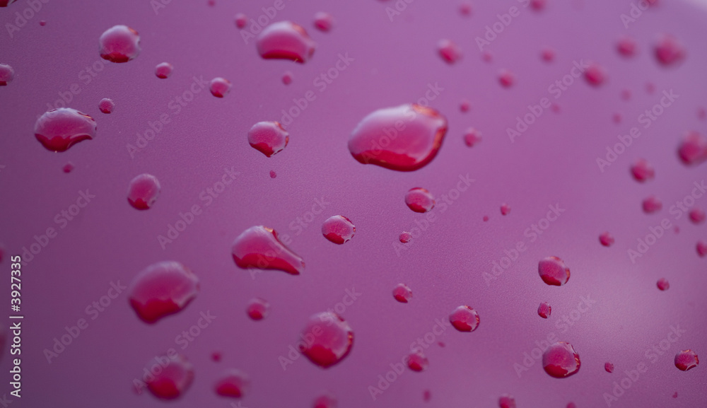 Water rain droplets on red glass background drop