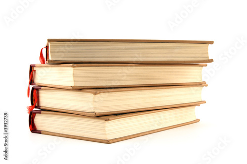 Four stacked hardcover books isolated on white background.