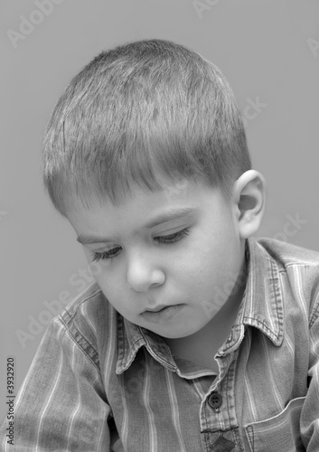 Foto little sadden boy portrait isolated over gray. black and white
