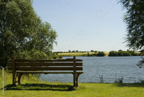 Old wooden bench by lakeside