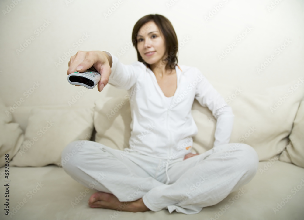 Young woman hold remote control in her hand Young woman hold remote control in her hand
