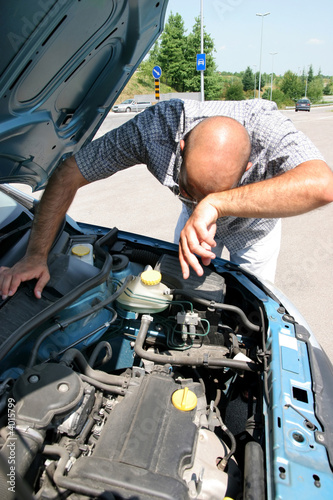 Businessman opening the trunk and checking the engine of a car