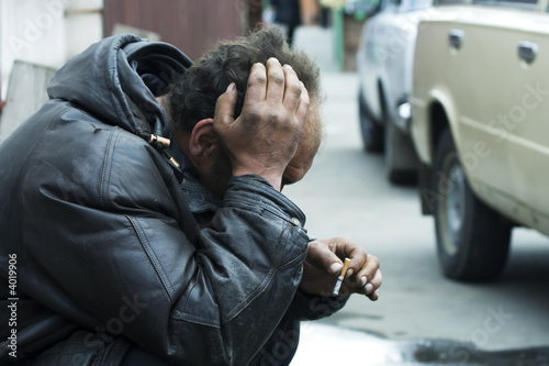 Sad homeless man on city street