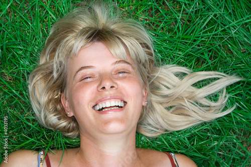 beauty blonde happy woman lie on grass photo