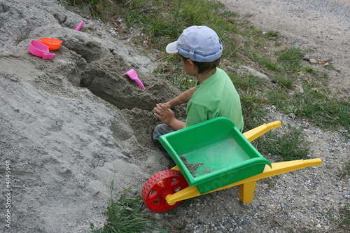 Enfant jouant sur un tas de sable photo