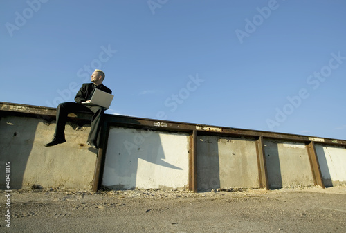 Punk Businessman on a Wall with Laptop Computer