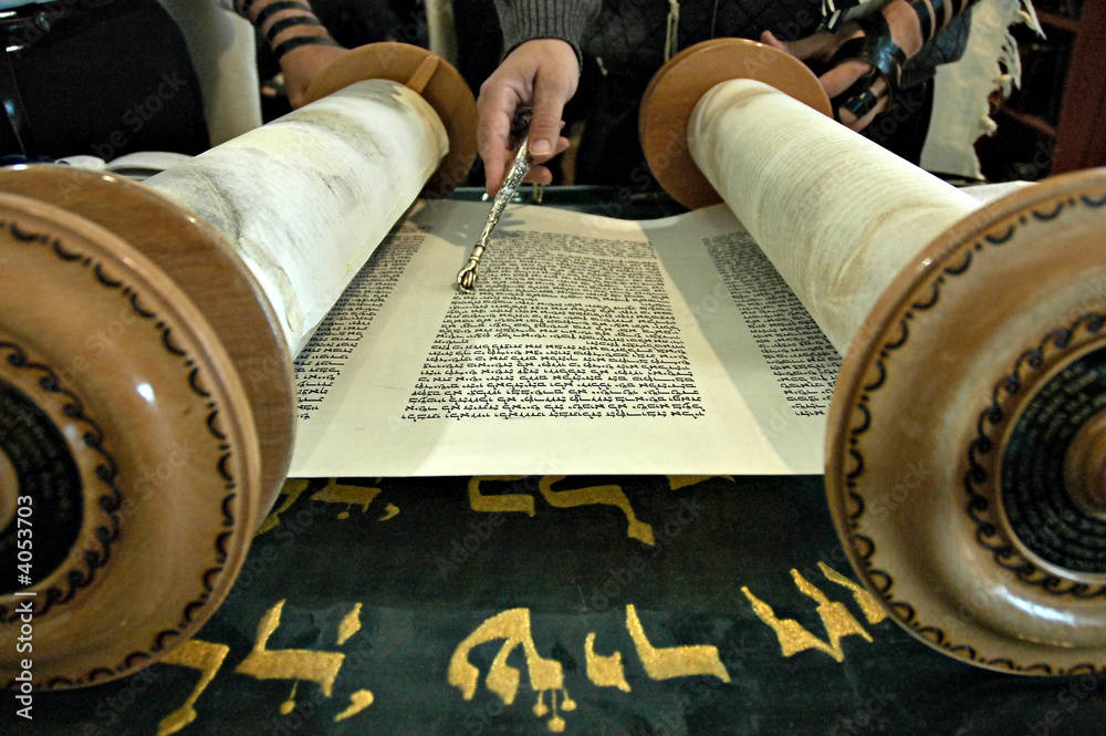 Obraz na plátně Torah  in a synagogue with a hand holding a silver pointer