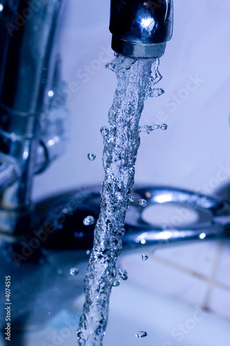 water running down from faucet in blue color