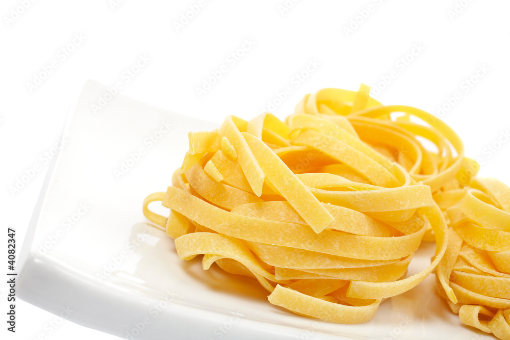 Uncooked pasta nest on a dish Uncooked pasta nest on a dish