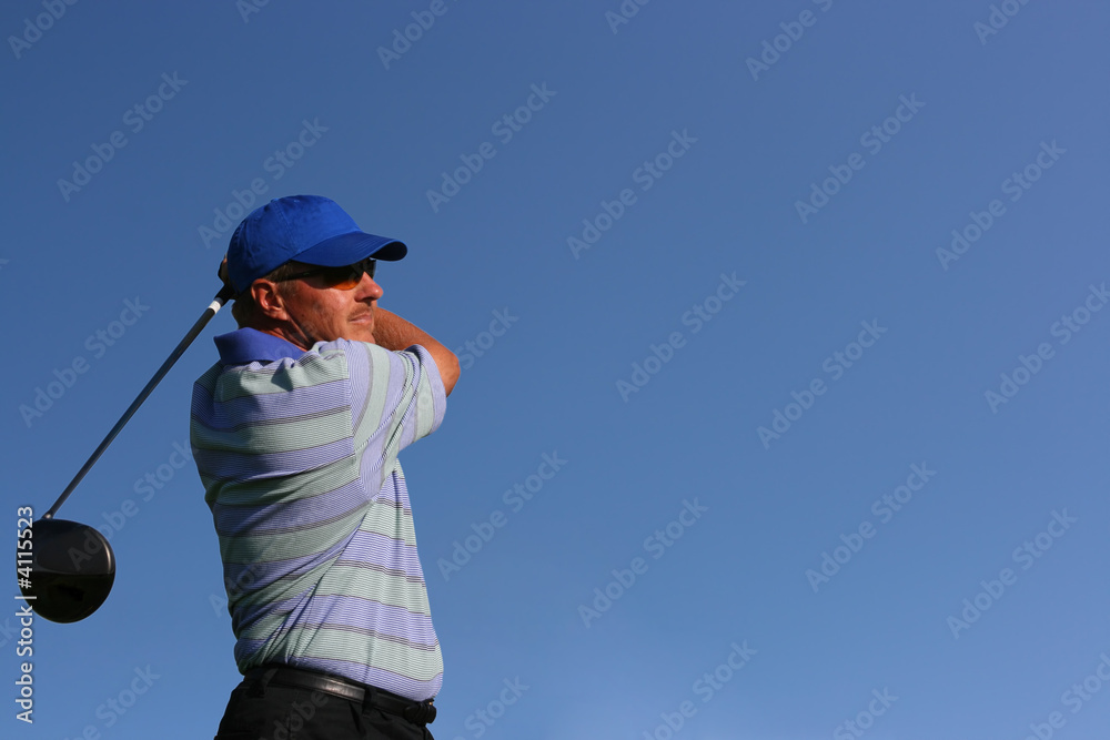 Close up of golfer teeing off on isolated blue Close up of golfer teeing off on isolated blue