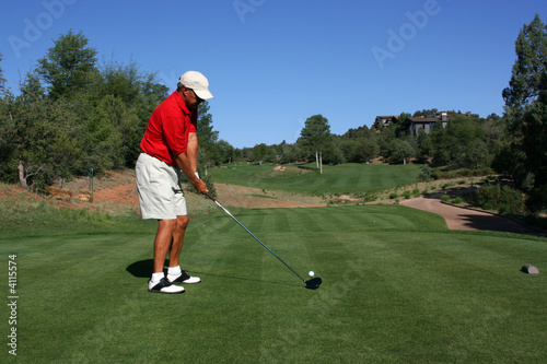 Golfer addressing ball, about to tee off