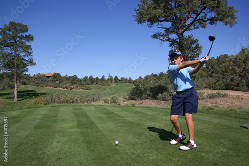 Young male golfer about to tee off on beautiful golf course