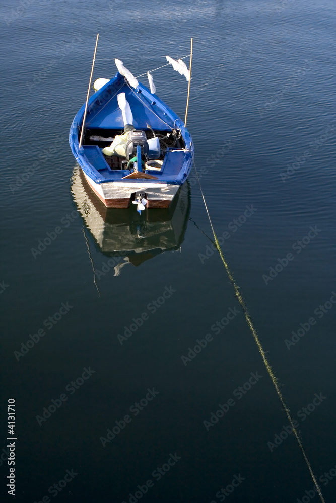 small blue fishing boat alone in the ocean