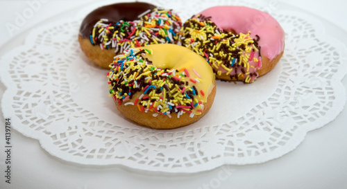 colorful iced donuts on white plate