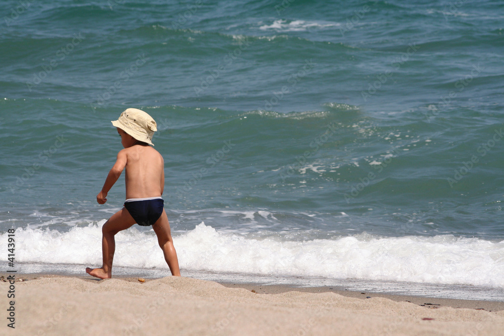 un petit garçon court dans les vagues un petit garçon court dans les vagues