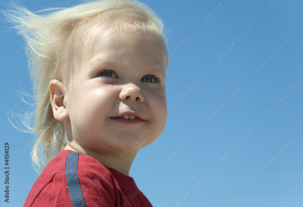 The blue-eyed boy with blond hair developing on a wind The blue-eyed boy with blond hair developing on a wind