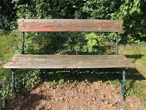 alte Sitzbank aus Holz und Metall mit Herzstein und Schatten