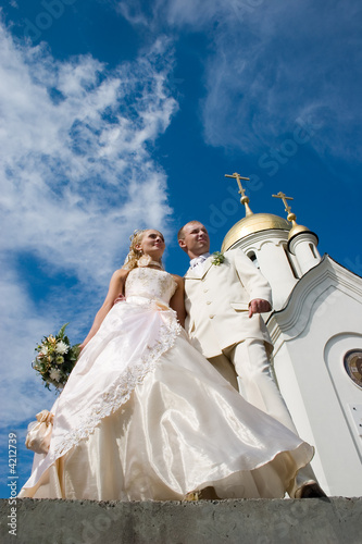 Newlyweds in front of church.