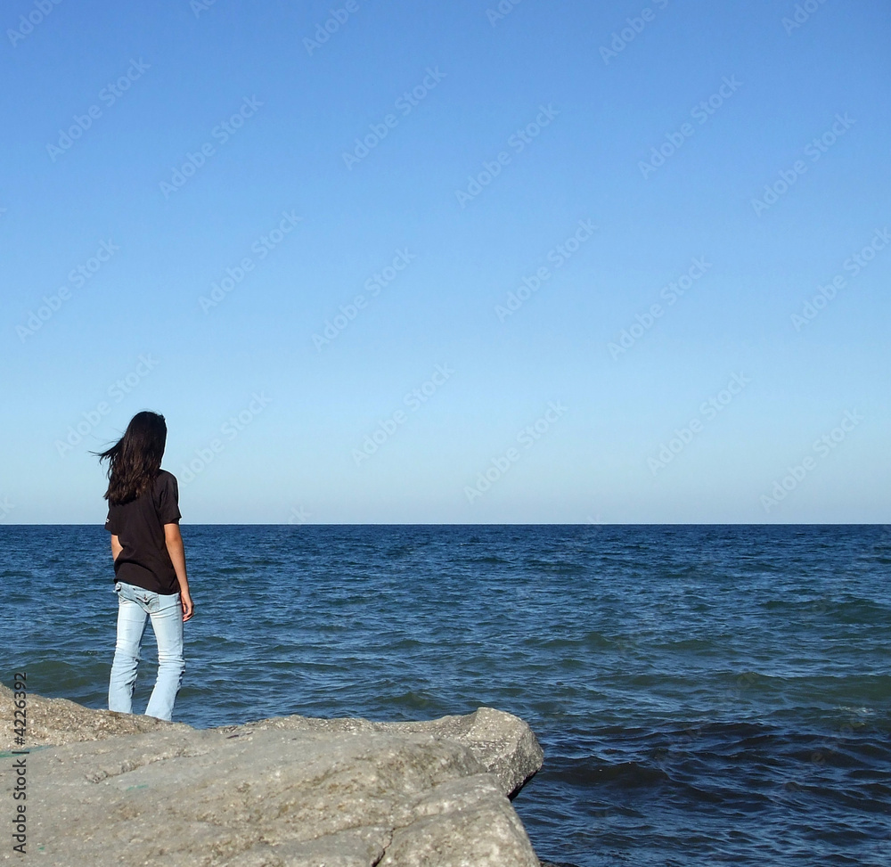 Girl Stands on Rock Looking At Water