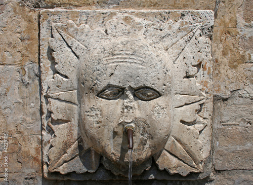 stone carved water fountain in assisi umbria italy