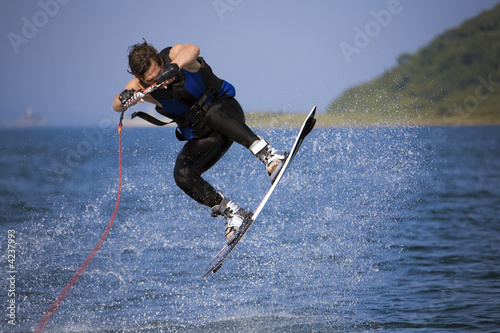 jumping wakeboarder in water splash