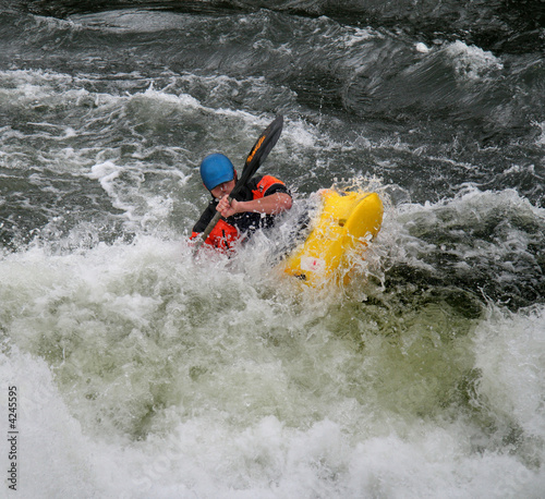 Man Paddling his Kayak on Whitewater Rapids photo