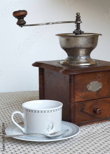 Coffee grinder and cup of coffee photo