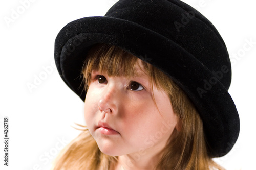 Little girl in black hat looking up