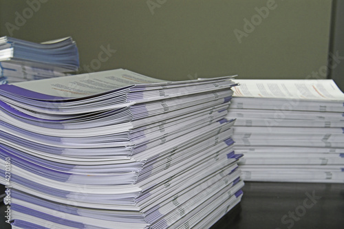 Piles of handout papers lying on a table. photo