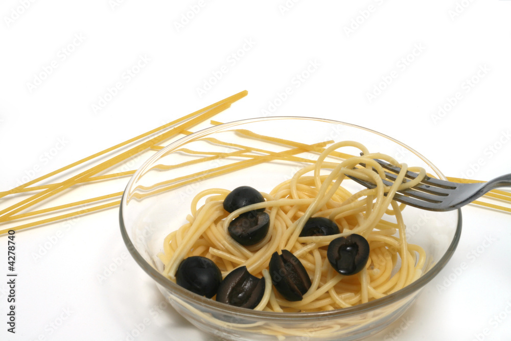 Spaghetti (Pasta) and black olives on a glass plate