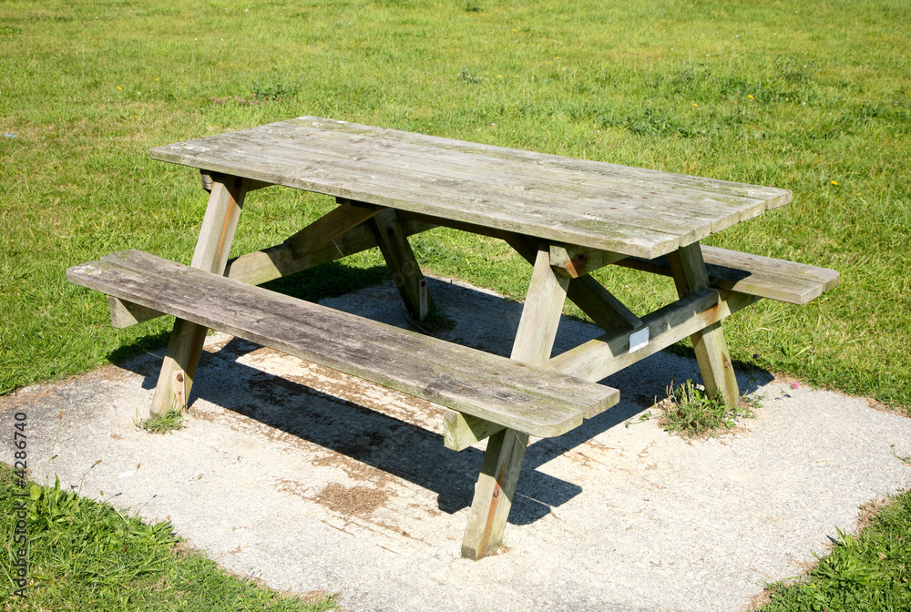 A wooden picnic bench table in a park.