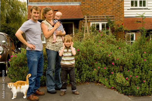 Family and Cat ourside their home