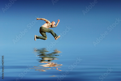 Athletic man jumping on water