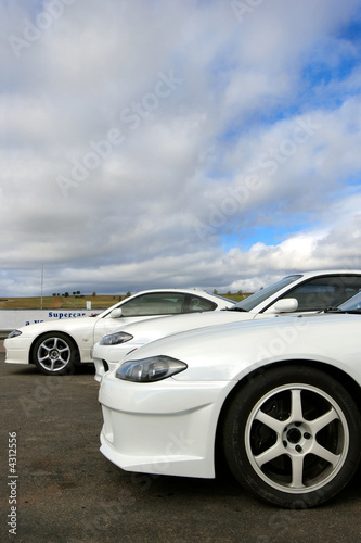 Three white sports cars at racetrack
