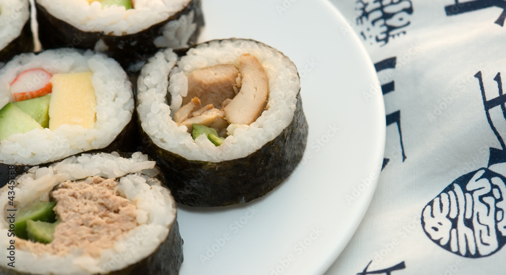 left aligned sushi rolls on plate with kimono background left aligned sushi rolls on plate with kimono background