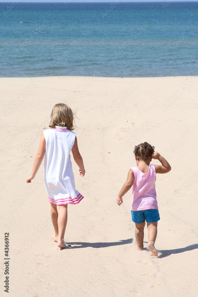 two kids walking on the beach