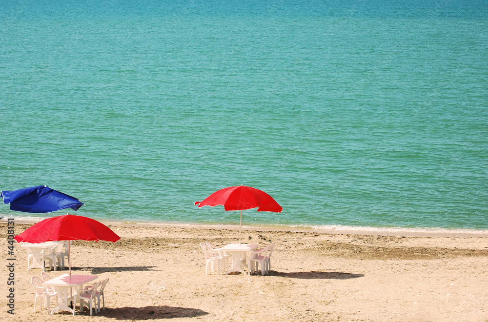 Three tables with parasols at summer beach