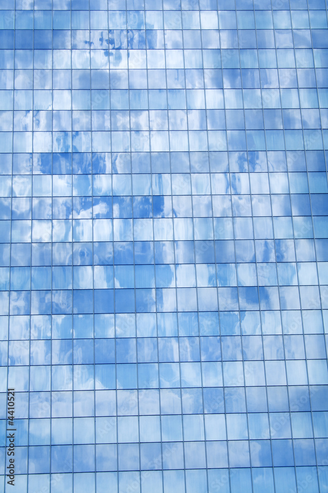 Tall building glass facade reflecting sky Tall building glass facade reflecting sky