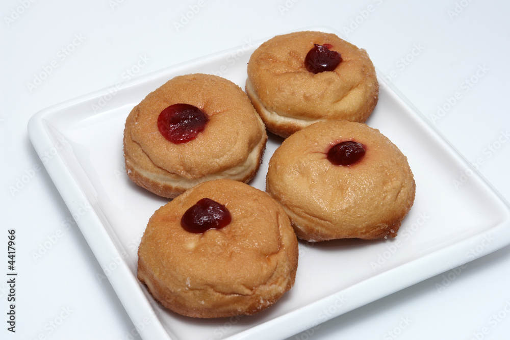 four jam donuts on white plate