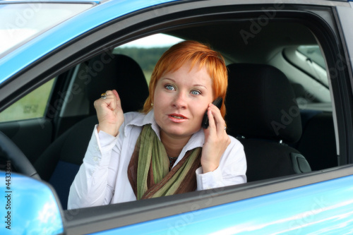 Red-haired woman with mobile-phone in a car, She is amazing