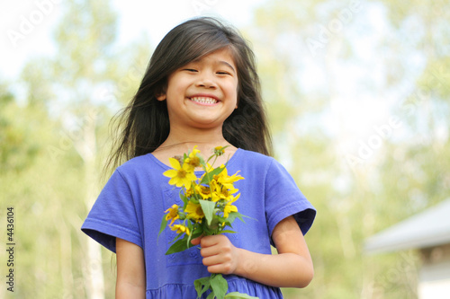 Little girl with a bouquet of fresh picked sunflowers