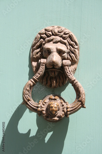 motivo clasico de llamador con forma de leon en puerta antigua