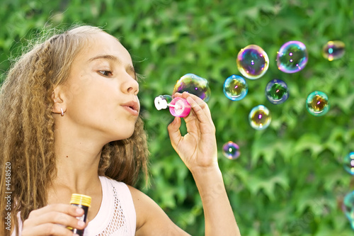 child blowing soap bubbles