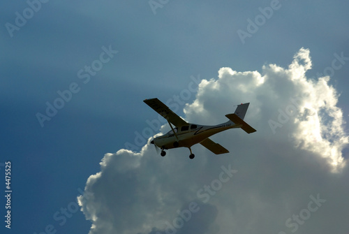  Silhouette of a small plane  with the clouds
