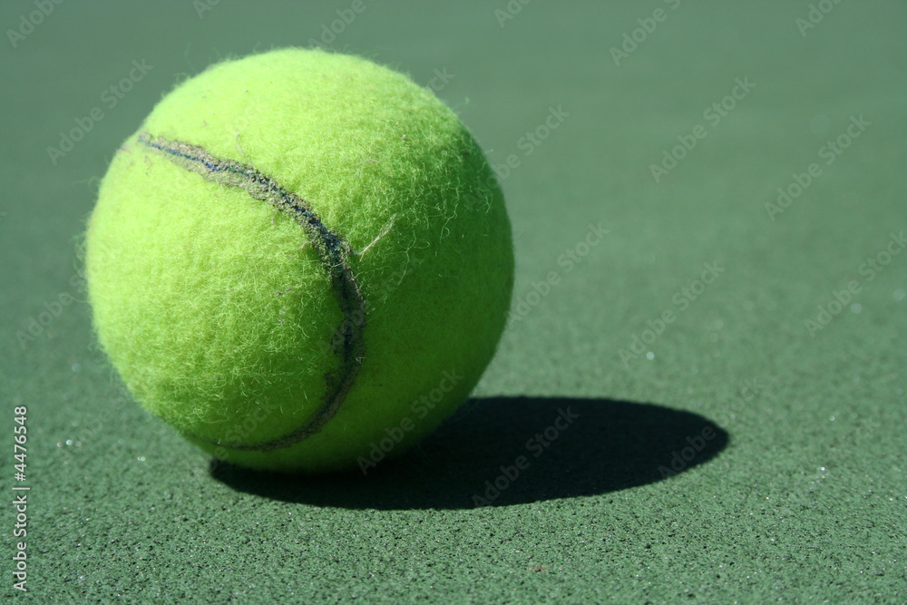 A Tennis ball on a green court