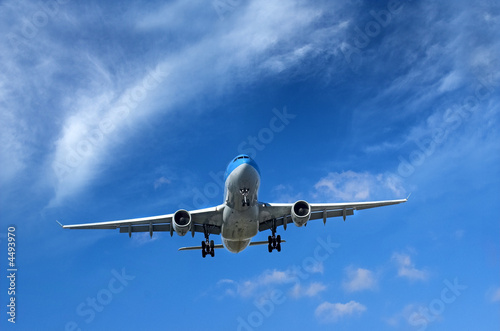 Airliner under wispy clouds