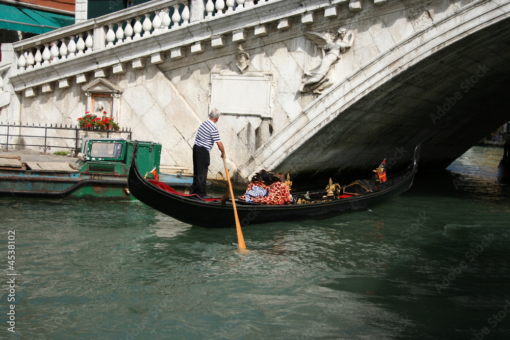 gondola passing under Rialto bridge Venice