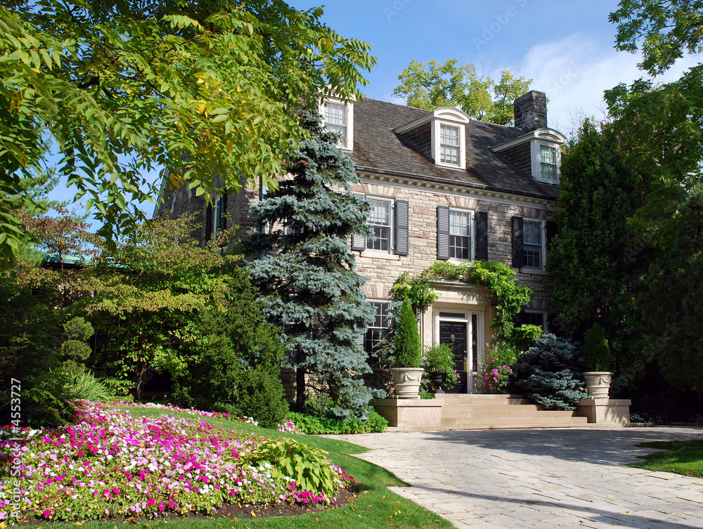 Two storey house with dormers, pine tree and impatiens